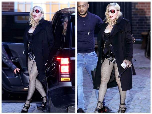 Madonna walks in a corset, almost revealing the chest