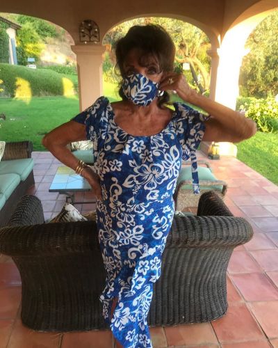 87-year-old Joan Collins posed in a blue dress and mask